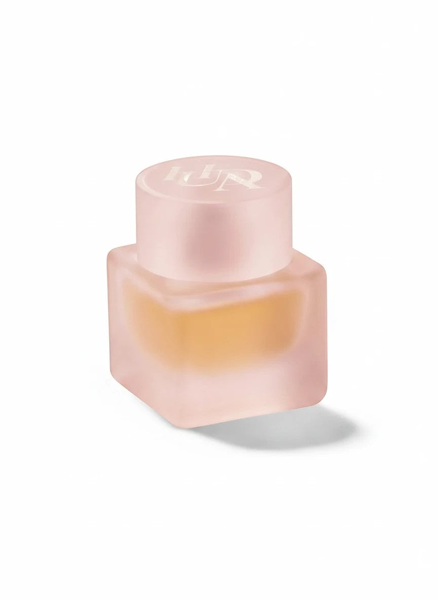 Flacon de parfum Easy Bake Intense TRENDY DISTRICT en verre dépoli rose avec liquide ambré. Bouchon rond gravé.
