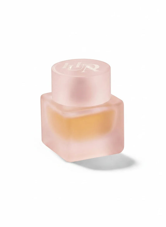 Flacon de parfum Easy Bake Intense TRENDY DISTRICT en verre dépoli rose avec liquide ambré. Bouchon rond gravé.
